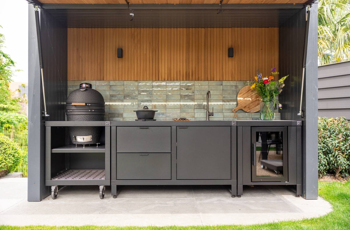 Modulaire buitenkeuken op wielen met kamado barbecue, spoelbak, kastruimte en koelkast onder overkapping